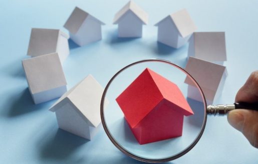 Red toy house under magnifying glass